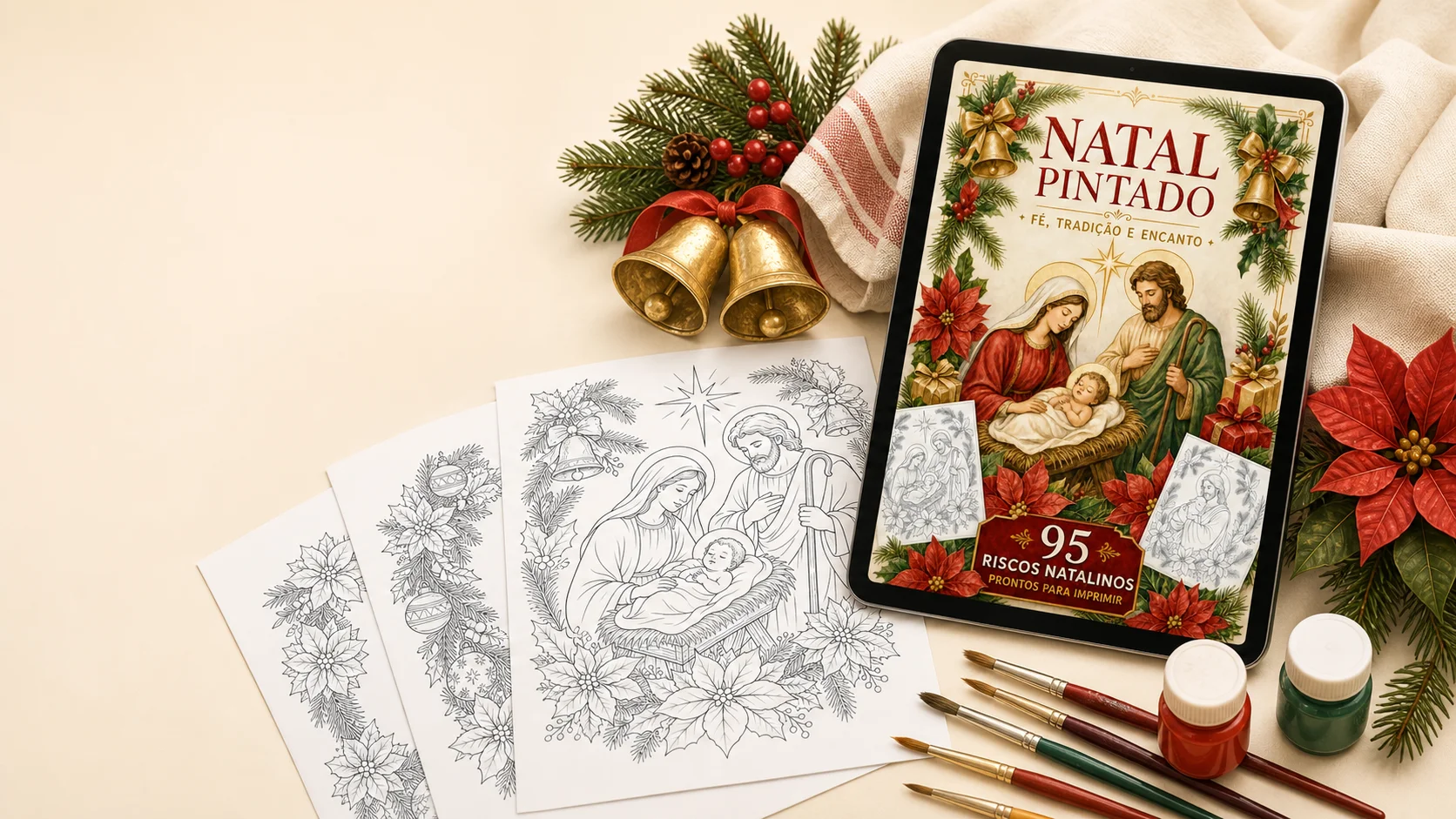 Riscos natalinos impressos ao lado de tablet mostrando a capa do Natal Pintado, com tintas e pincéis para pintura em tecido